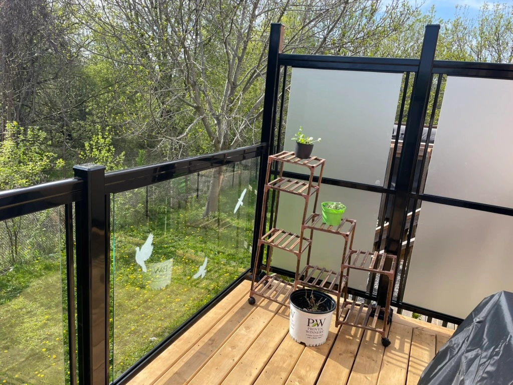 Black aluminum and glass deck railing with frosted privacy panel