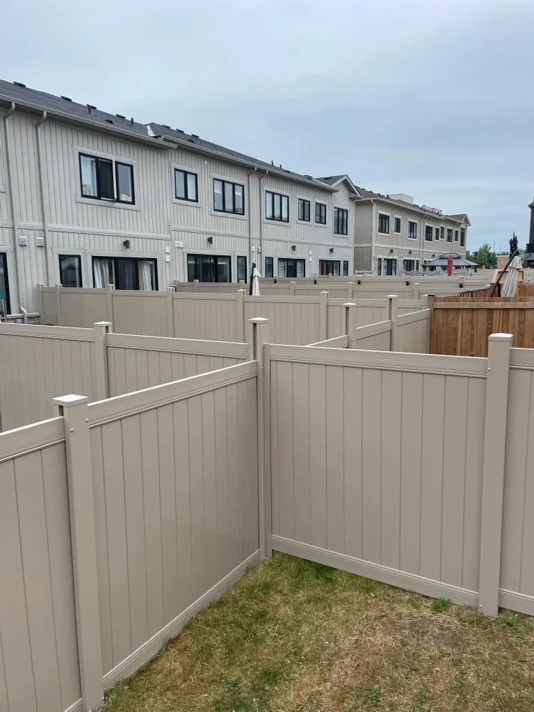 Beige vinyl fence installed in a residential subdivision