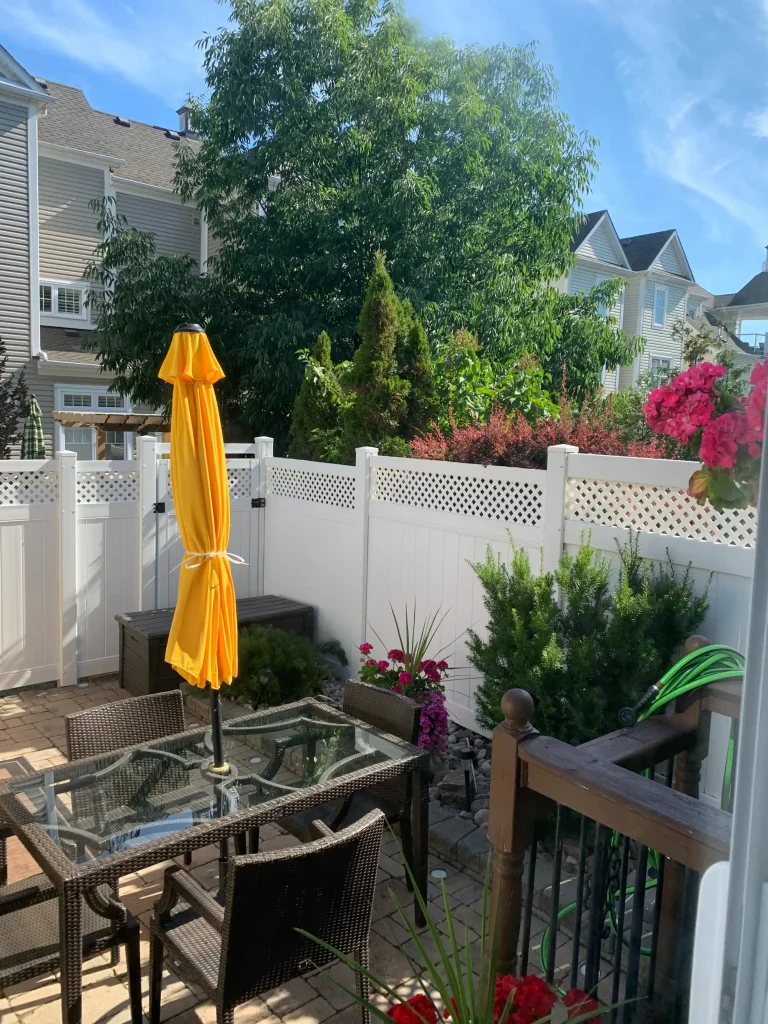 White vinyl fence in a backyard during summer