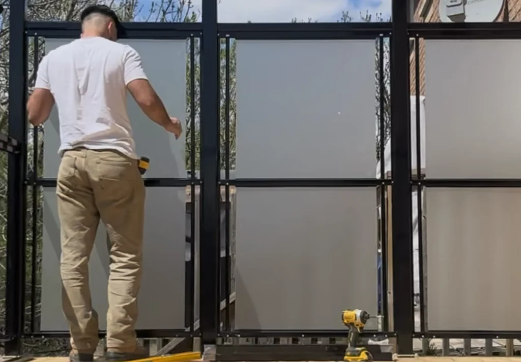 Modern black aluminum railing with frosted glass privacy panels installed for a backyard deck in Ajax.