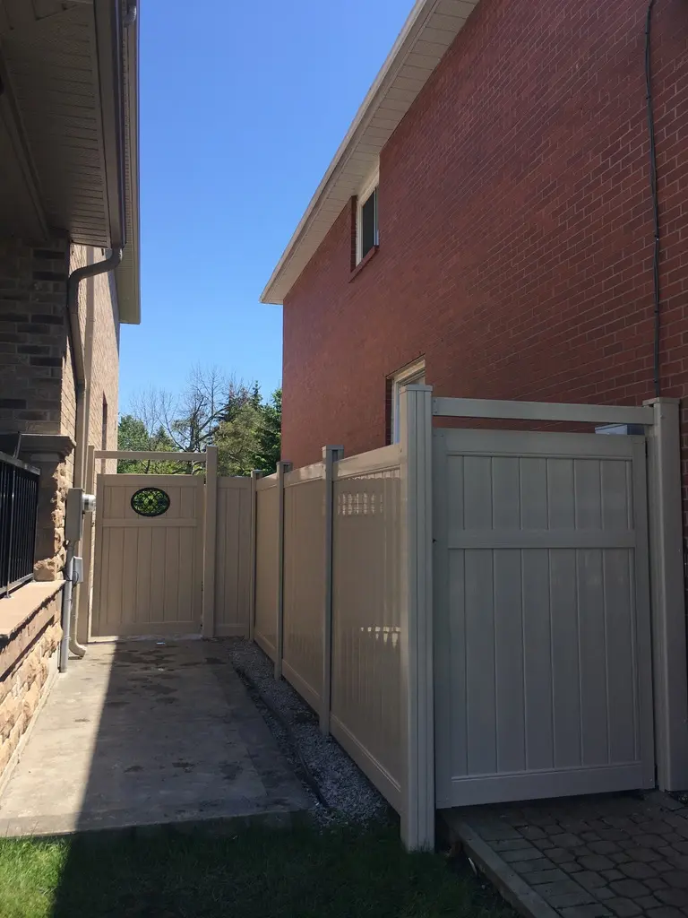 Durable beige vinyl privacy fence and matching gate system installed for a secure backyard entrance in Pickering.
