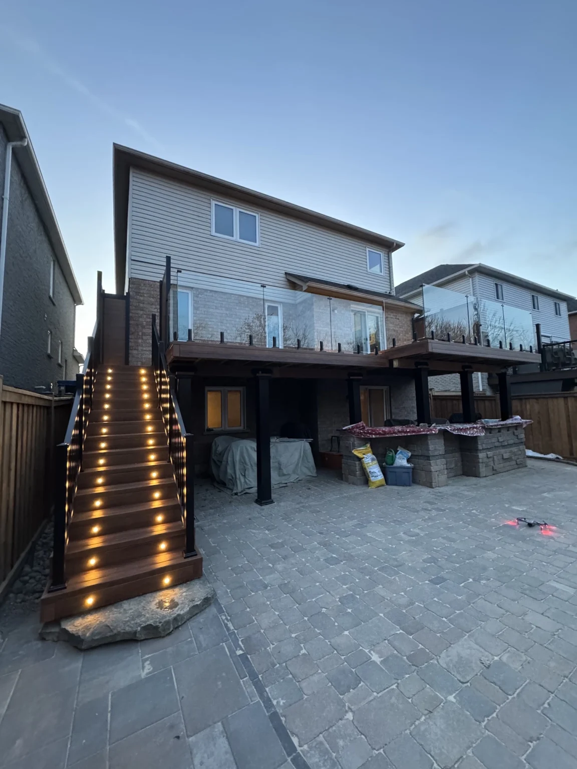 Completed custom deck in Bowmanville featuring integrated LED stair and post cap lighting for evening ambiance.