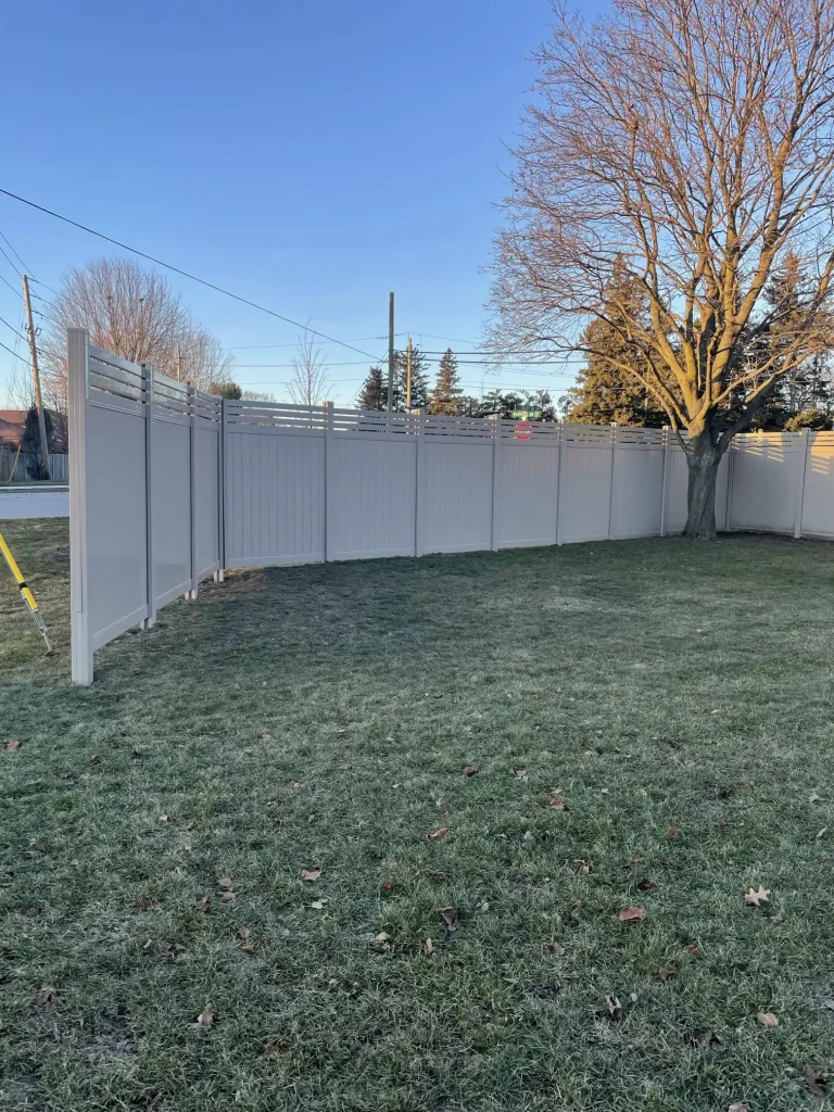 Partial view of a beige vinyl fence section showcasing the clean finish and seamless installation in Bowmanville.