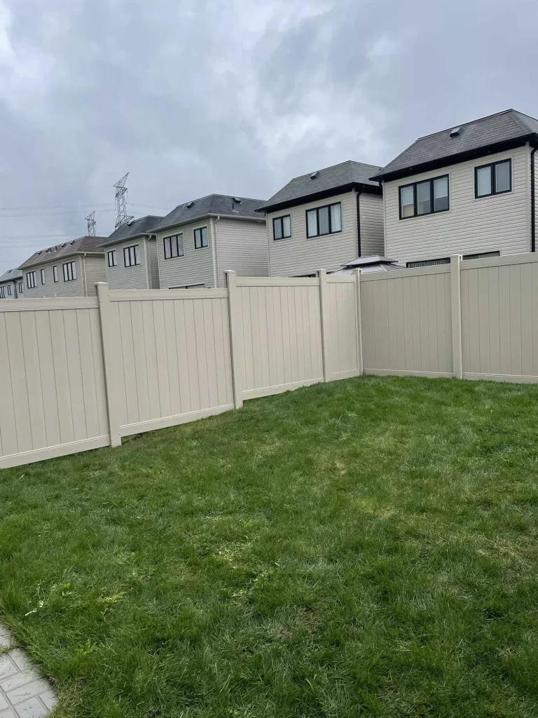 Durable beige vinyl privacy fence installed for a single-family home in a Bowmanville neighborhood.