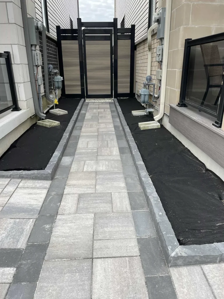 Close-up of a matching black vinyl gate with heavy-duty hardware installed on a privacy fence in Bowmanville.