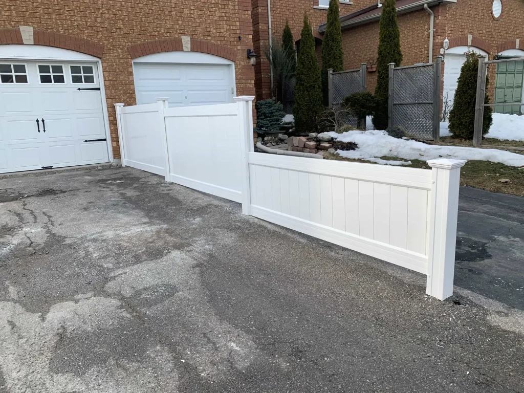 Professional white vinyl fence installation in Bowmanville clearly delimiting the property line of a residential backyard.