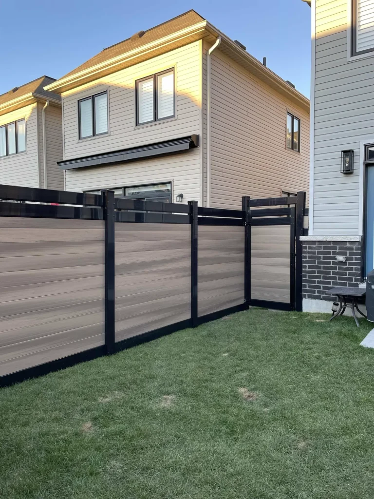 Close-up of a textured brown vinyl privacy fence installed in Bowmanville, offering the look of wood with low-maintenance benefits.