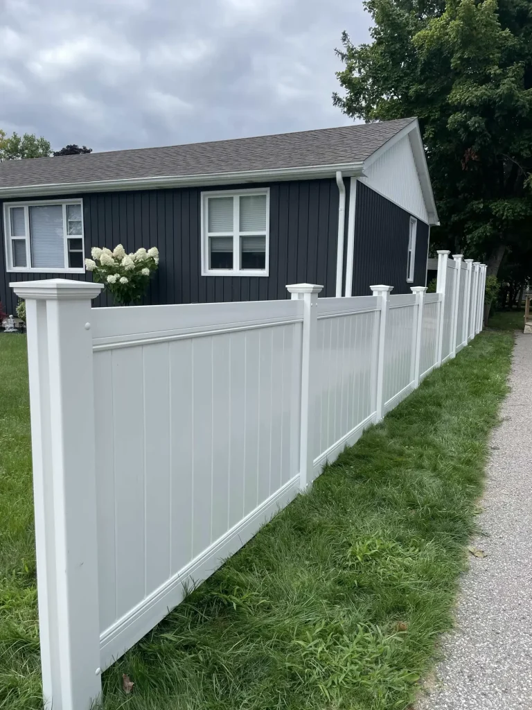 Professional installation of a classic white vinyl privacy fence for a residential property in Bowmanville.