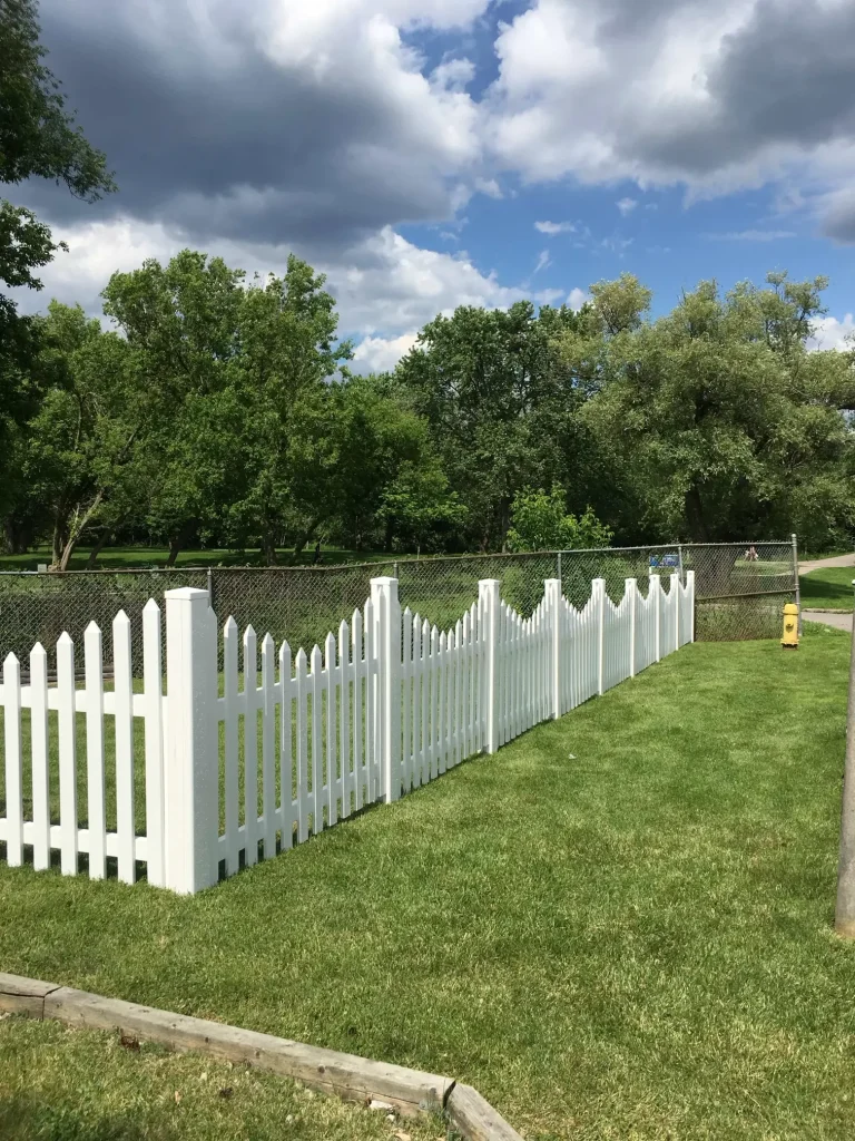 Classic white vinyl picket fence installation for a front yard landscape in Bowmanville.