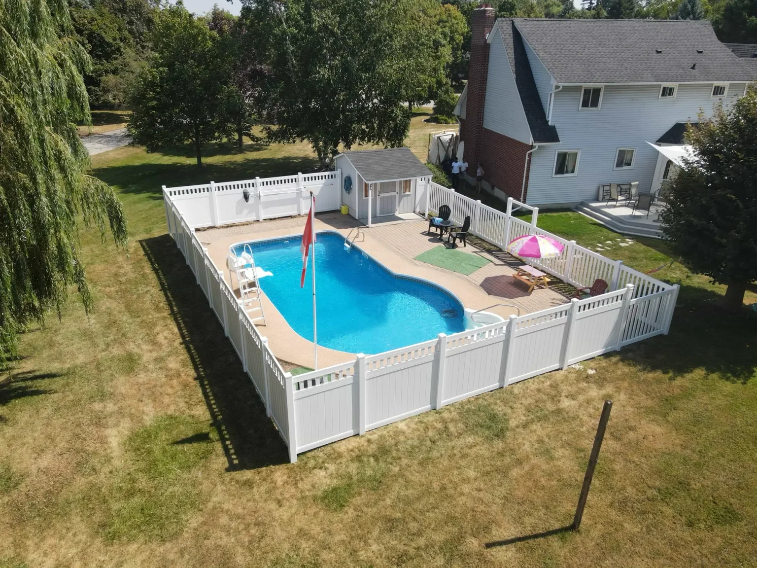 Durable white vinyl privacy fencing providing a clean aesthetic and security for a Bowmanville pool area.