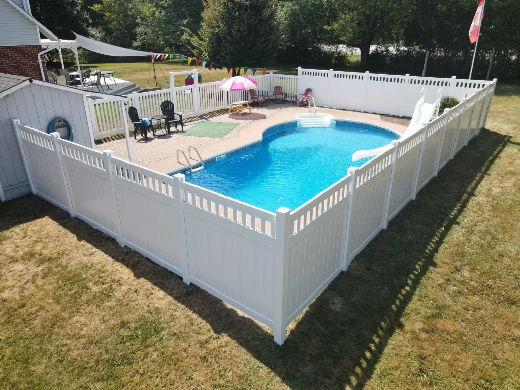 Detailed view of a professional white vinyl fence corner installation surrounding a backyard swimming pool in Bowmanville.