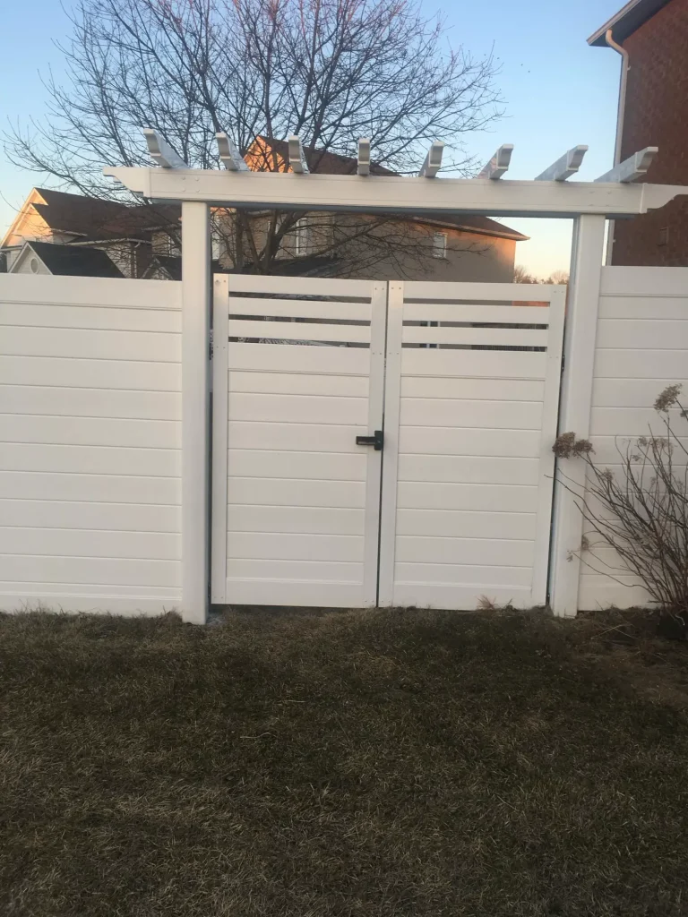 Professional installation of a Bowmanville vinyl privacy fence featuring a modern horizontal trellis gate for a secure and stylish backyard.
