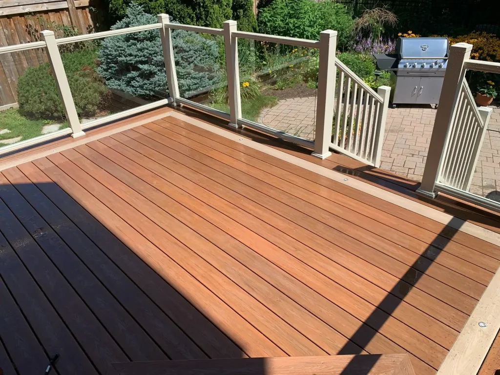Custom backyard pergola paired with a frosted glass privacy railing system for a secluded outdoor living space.