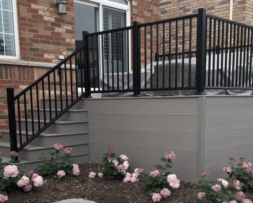 Contemporary composite deck in Whitby, Ontario, featuring a high-contrast black aluminum railing system.