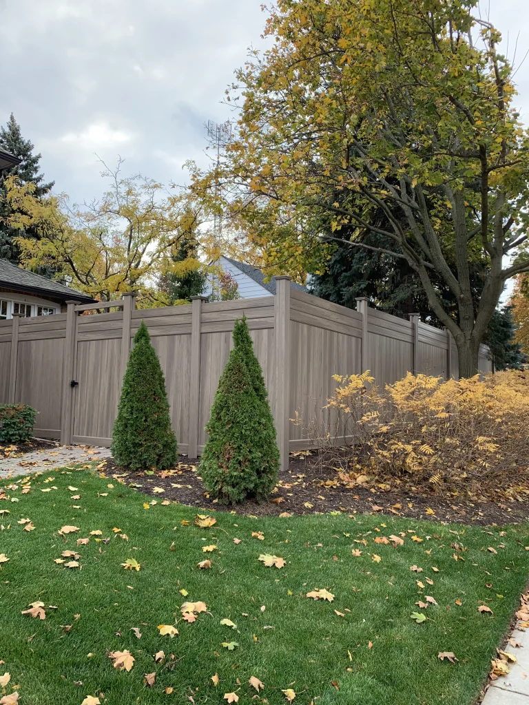 Outside angle of a sturdy beige vinyl fence gate installed for a residential property in Oshawa, Ontario.